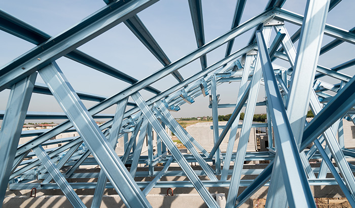 Blue steel structure with matching blue roof, standing tall against clear sky.