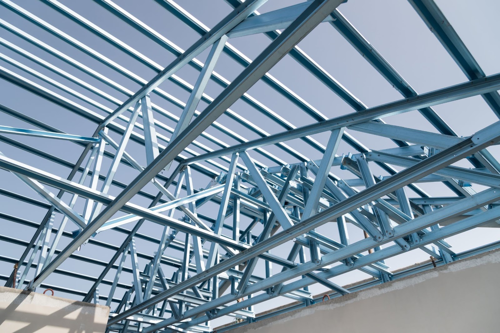 Blue steel trusses supporting a blue roof on a steel structure