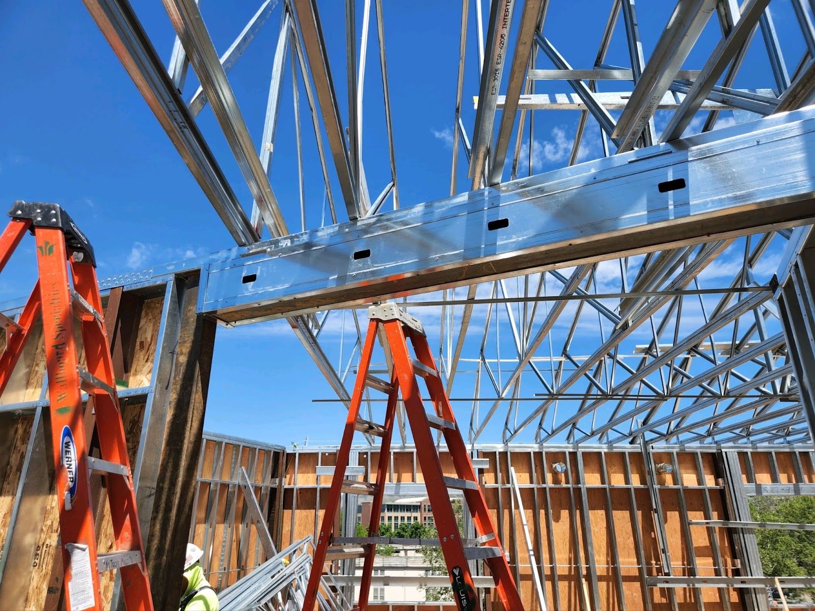 A construction worker assembling prefabricated wall panels on a building, ensuring structural integrity