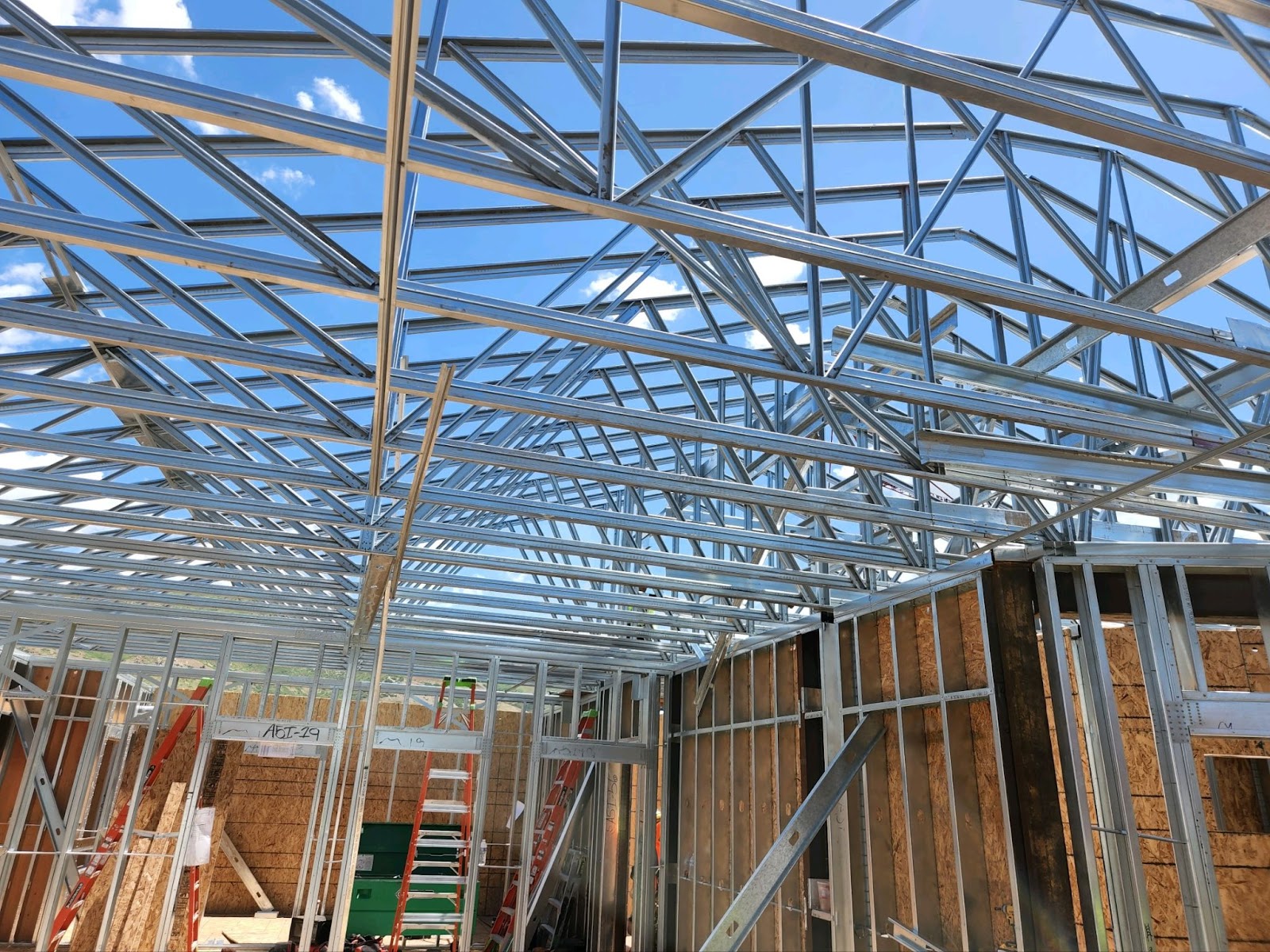 Construction of metal roof structure with prefabricated wall panels for added strength
