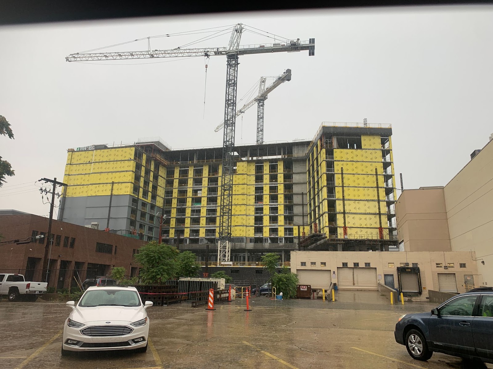 Image of a crane overseeing the construction of a large building with prefabricated wall panels