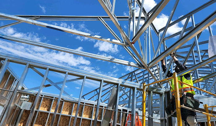 Construction Worker Working On Steel Structure With Wall Panels, Ensuring Structural Integrity